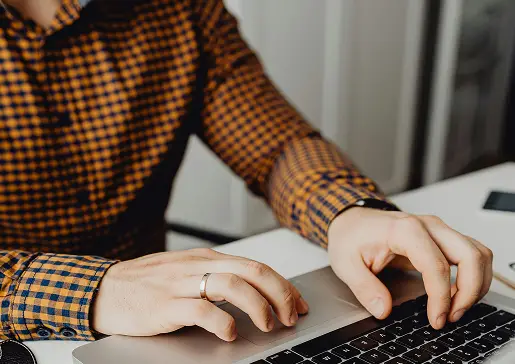 Hands typing on a laptop