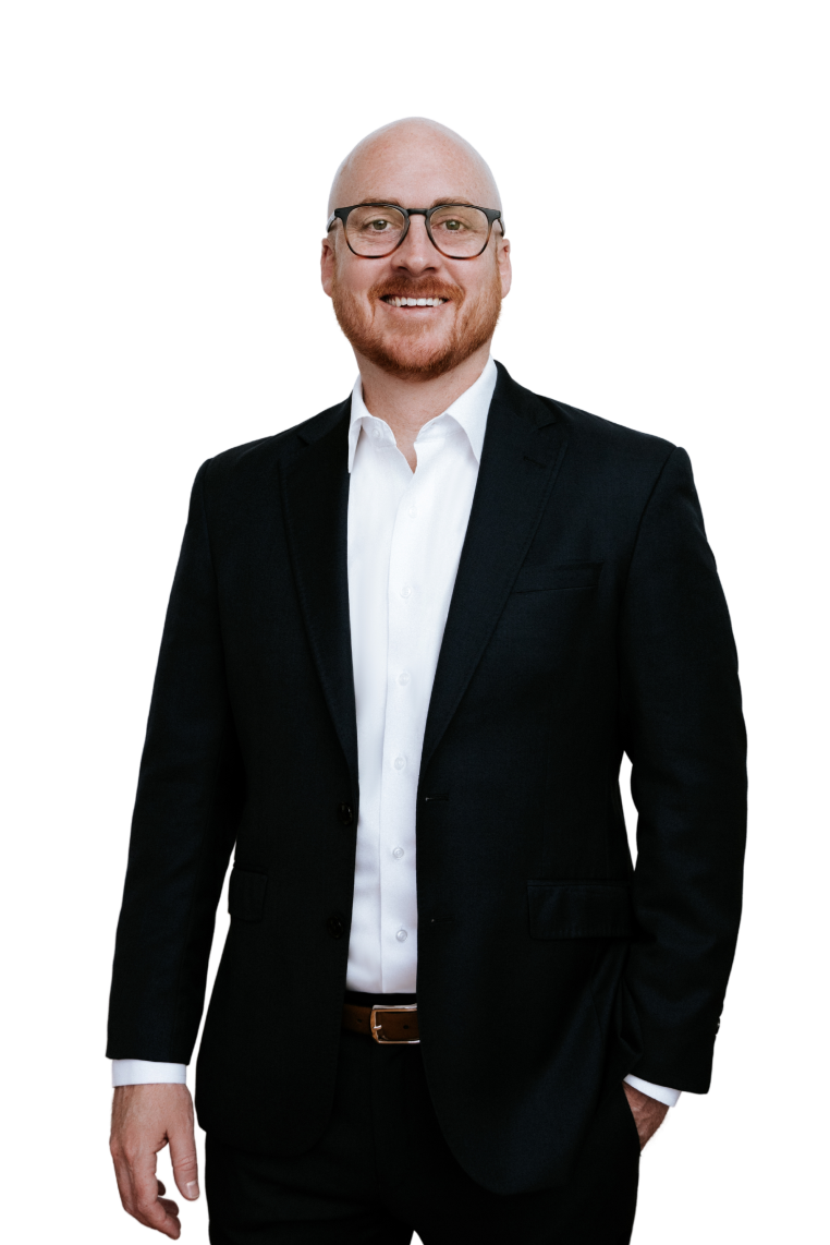 Robert Peck standing with his hand in his pocket looking at the camera, smiling.