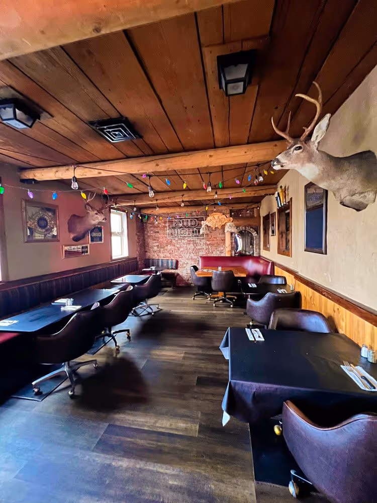 A restaurant with a fireplace and wooden furniture.