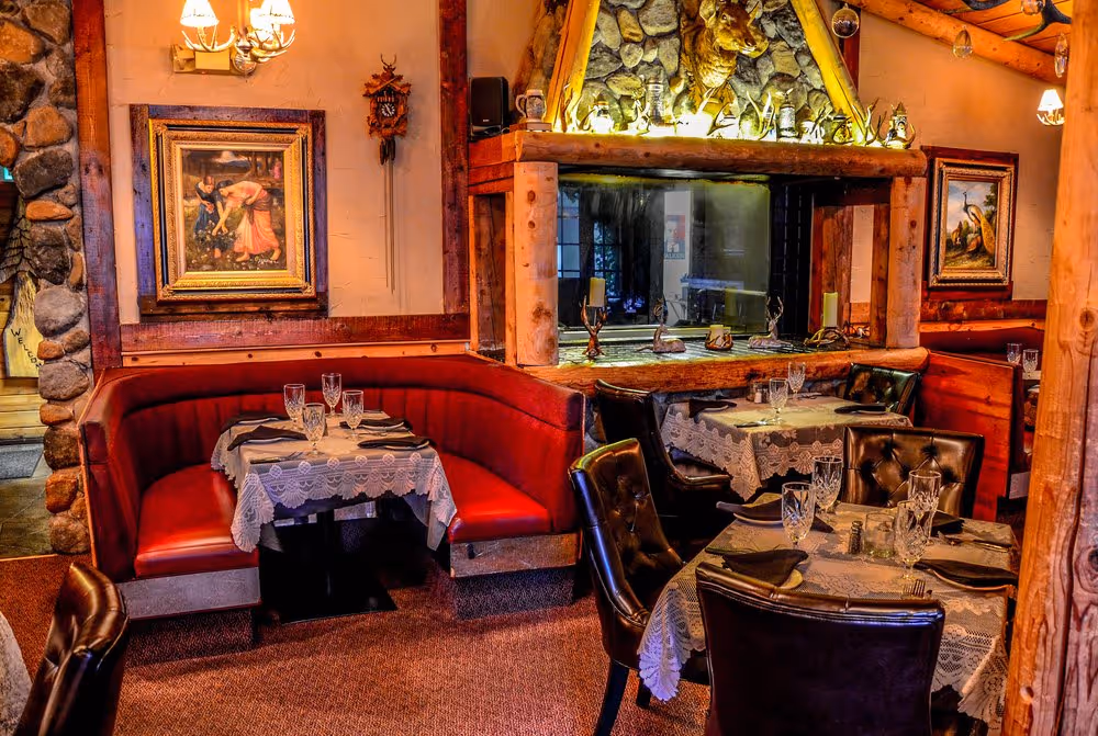 A restaurant with a fireplace and wooden furniture.