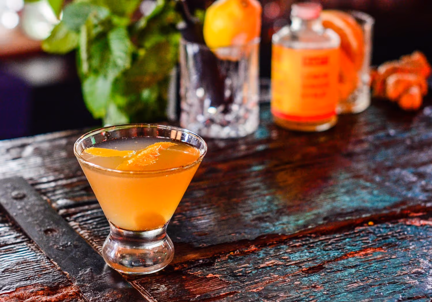 A glass of orange juice with a slice of lemon in it.