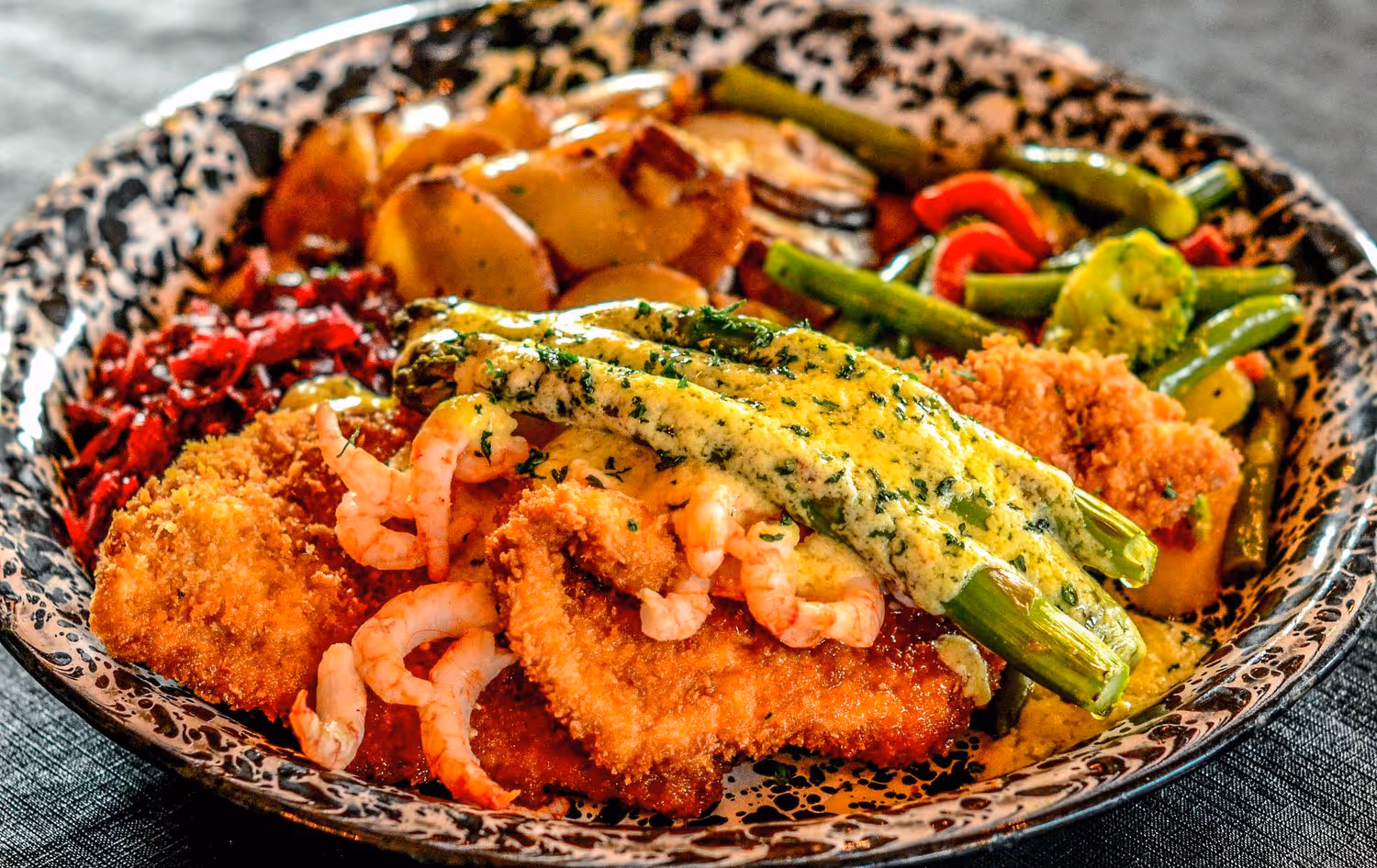 A plate of food with shrimp, potatoes, and green beans.