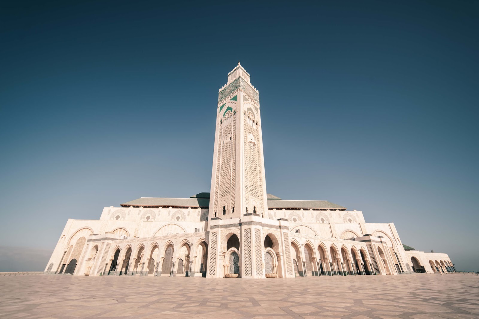 The grand Hassan II Mosque in Casablanca under a clear blue sky during a tour with Moroccan Guides Travel