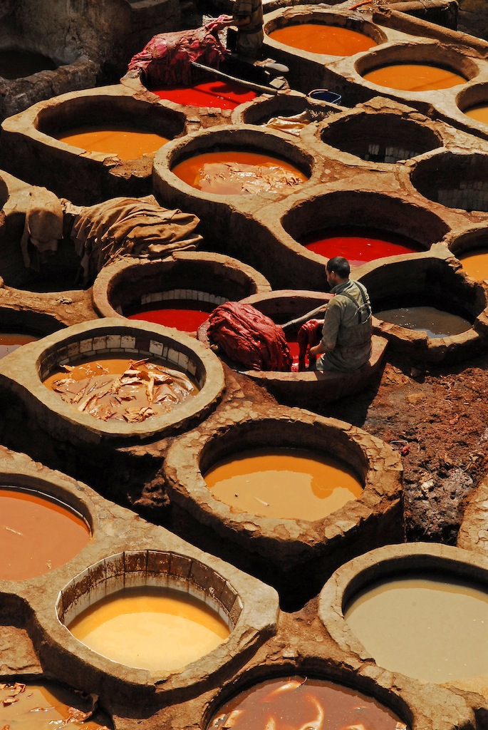 Colorful leather tanning vats with workers in traditional Moroccan tannery in Fes Morocco