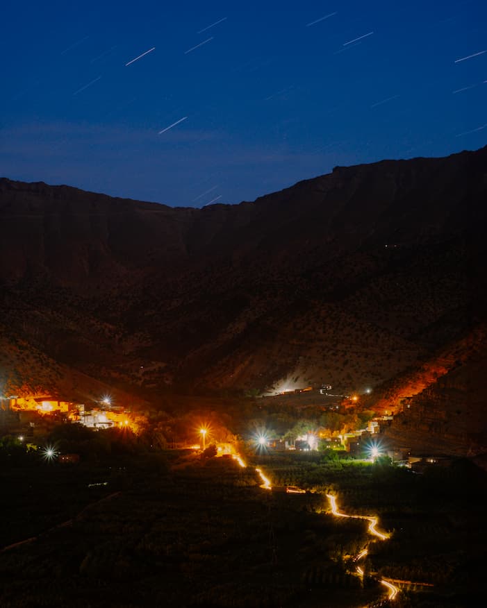 Night view of Happy Valley Ait Bougemez in the central high atlas Morocco village with glowing lights and star trails