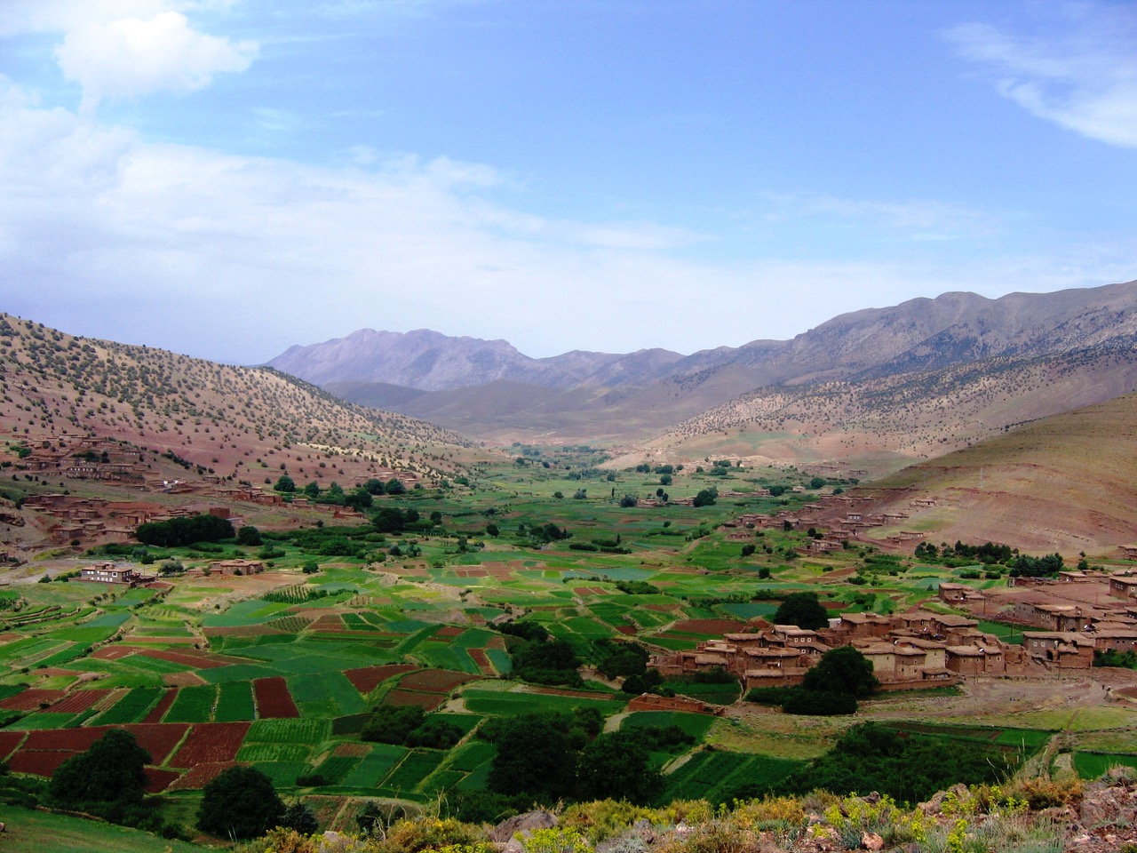 Aït Bougemez happy valley with green agricultural fields and traditional village buildings