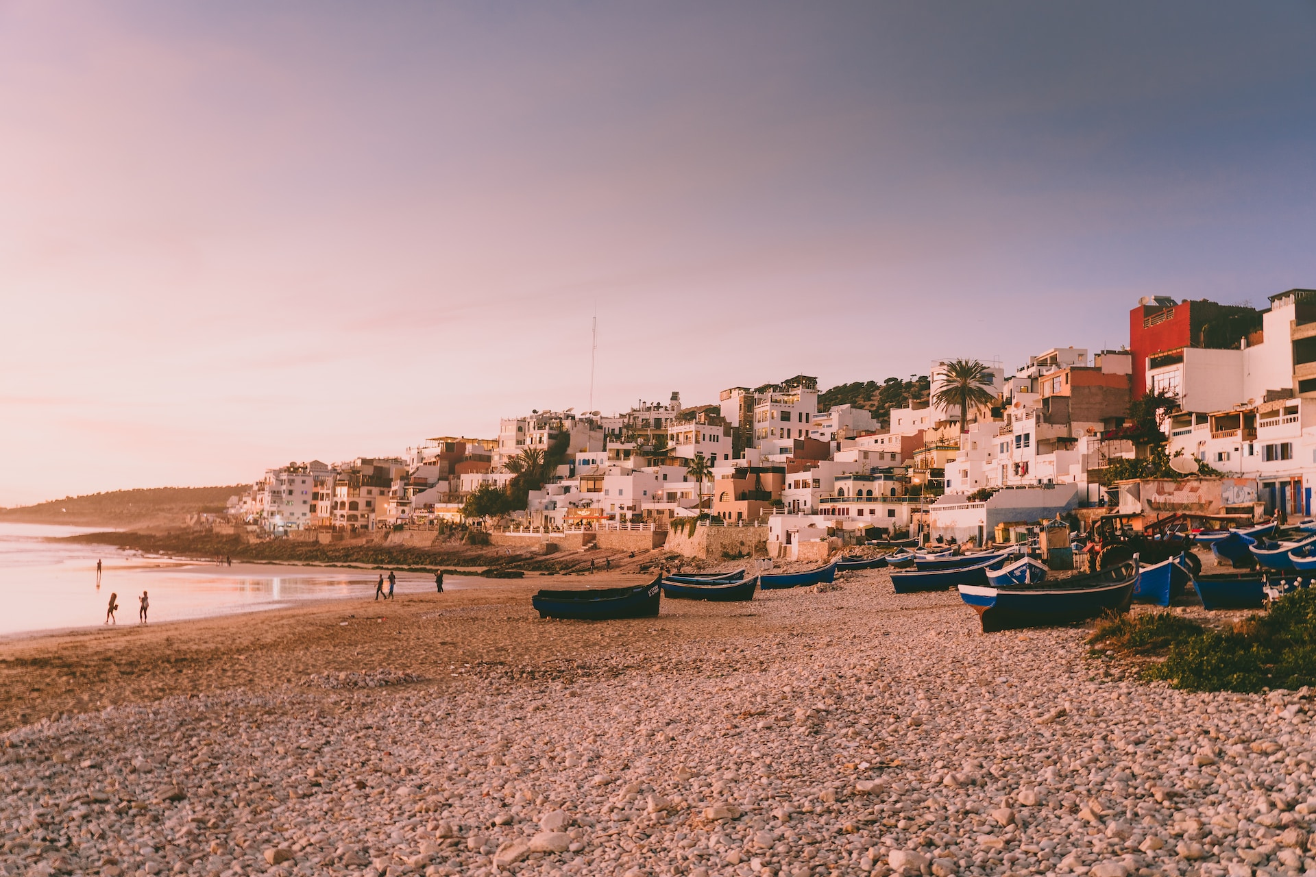 Coastal town Of Taghazout with white buildings and fishing boats on rocky Mediterranean beach