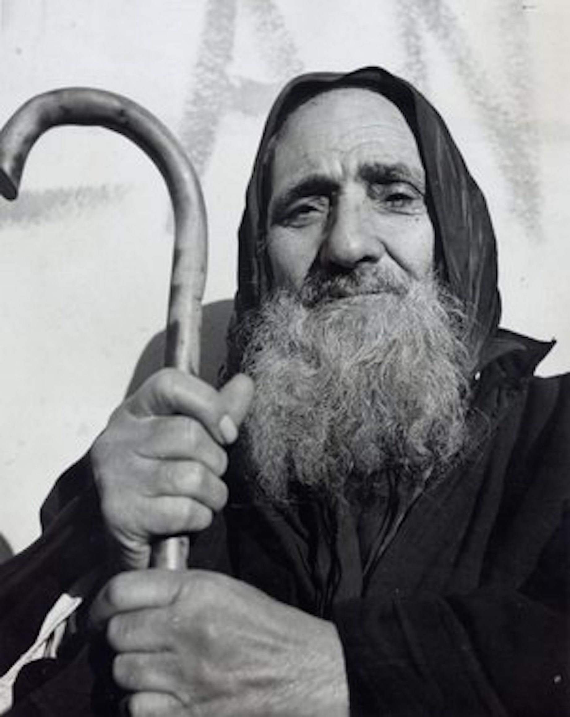 Close-up black and white portrait of an elderly Jewish man with a long beard holding a traditional wooden staff during a cultural tour with Moroccan Guides Travel.