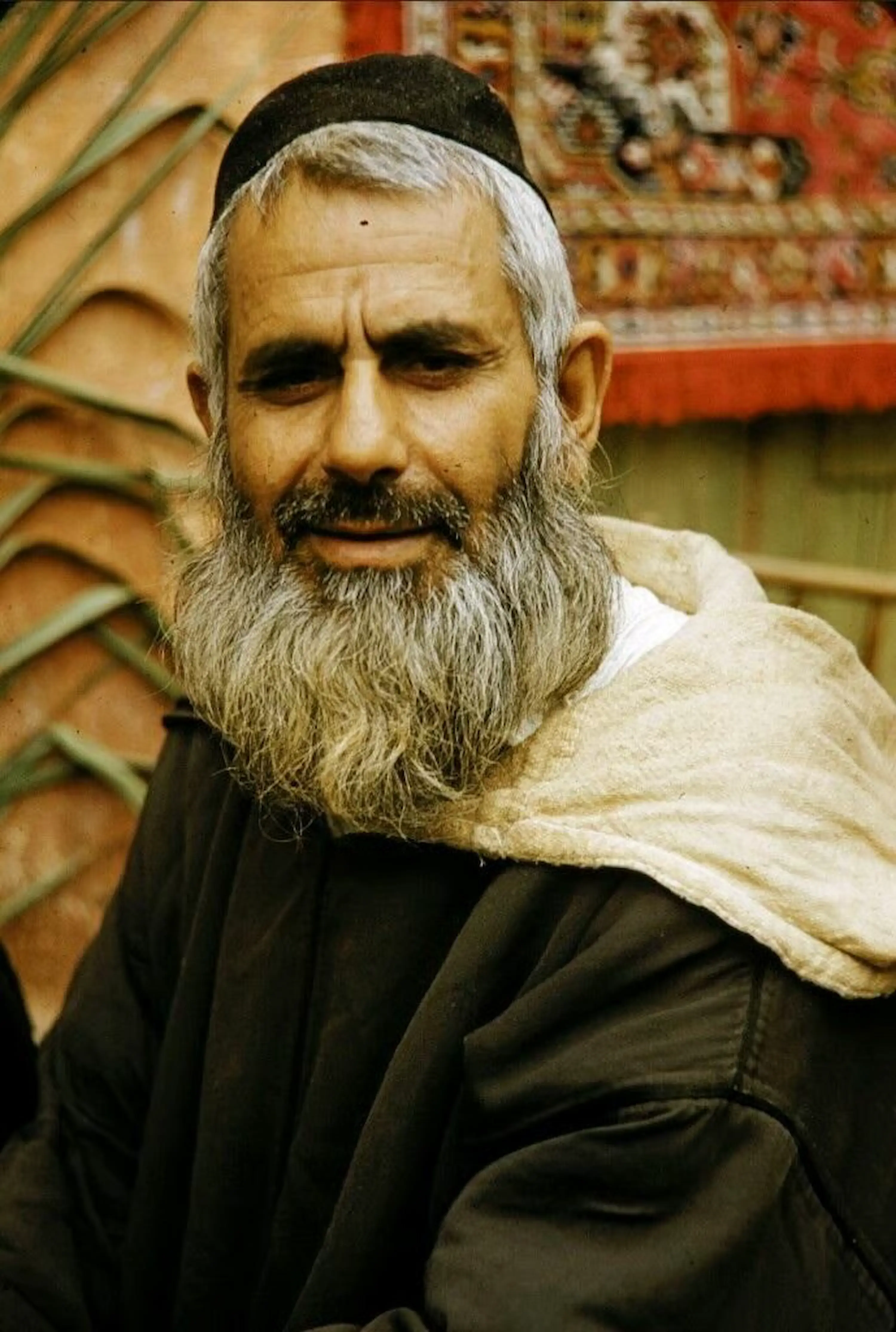 Close-up portrait of a traditional Moroccan Jewish man with a grey beard wearing a kippah during a cultural tour with Moroccan Guides Travel.