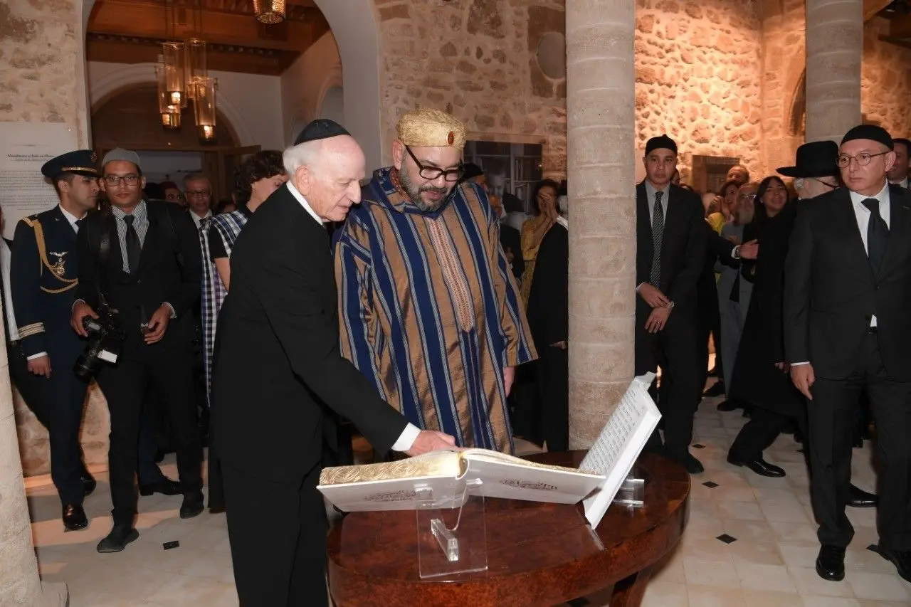 King Mohammed VI of Morocco reviewing an open historic Jewish manuscript alongside a community representative on a heritage tour with Moroccan Guides Travel.