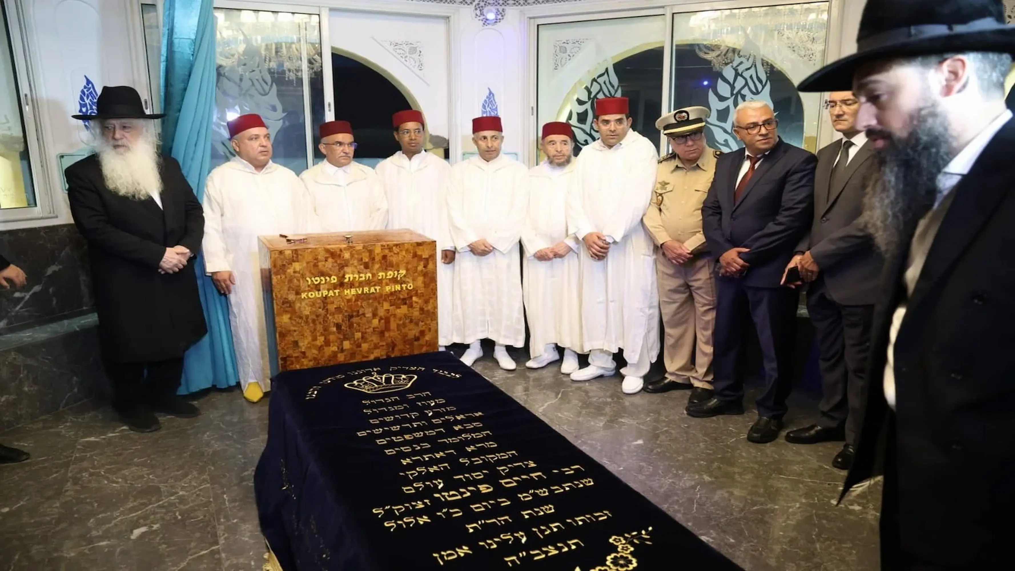 Jewish rabbis and Moroccan officials gathered around the sacred Koupat Hevrat Pinto memorial tomb during a heritage experience with Moroccan Guides Travel.