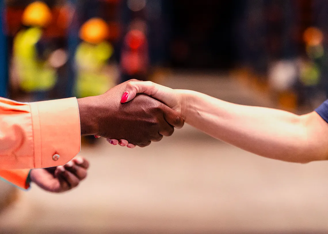 Duas pessoas apertando as mãos.