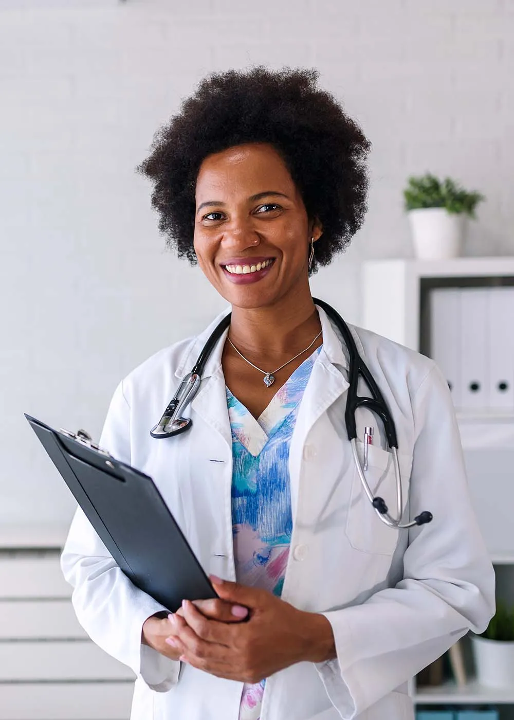 Smiling female doctor with stethoscope holding a clipboard