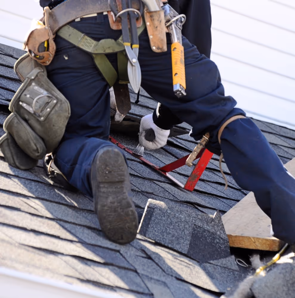 Roofer on the roof installing shingles
