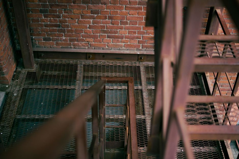 Rustic industrial staircase with metal steps against a brick wall, offering a vintage urban feel.