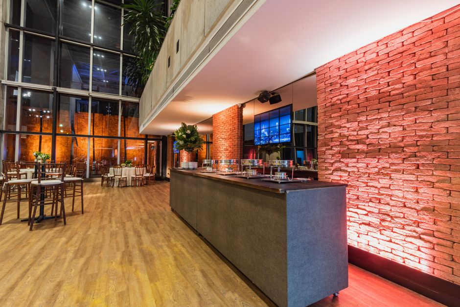 Spacious modern restaurant interior featuring brick walls, stylish lighting, and elegant seating arrangements.
