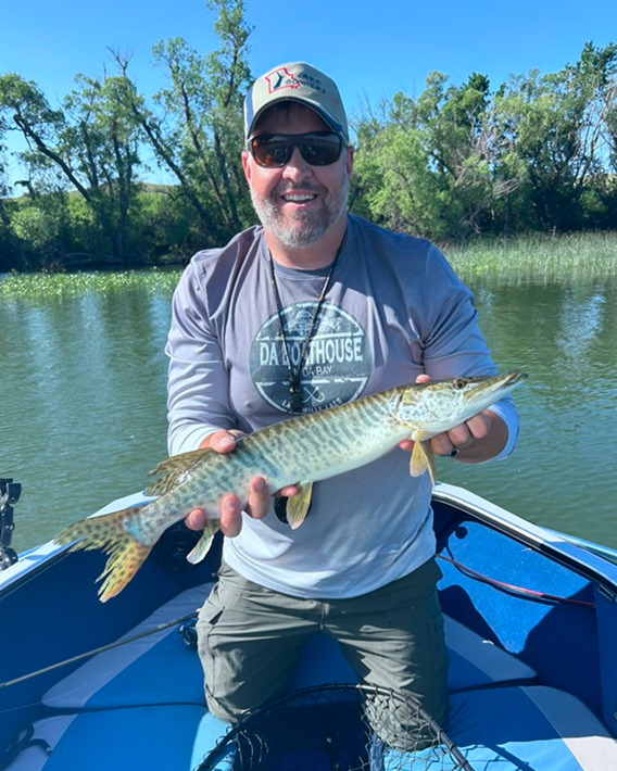 Image of Dustin Dam holding a large fish on a boat