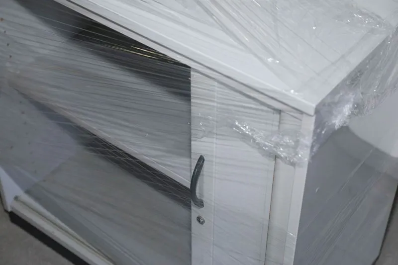 Ein leerer Aktenschrank mit Einlegeböden ist vollständig mit Schutzfolie umwickelt und für den Transport vorbereitet.