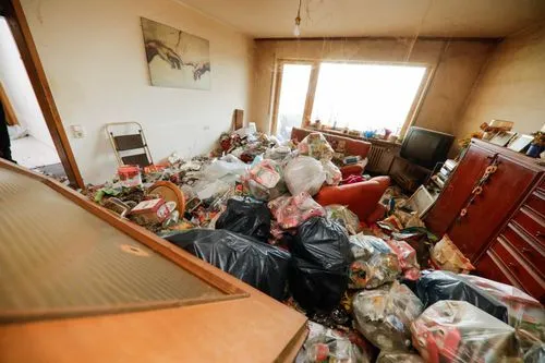 Volles Wohnzimmer einer Messiewohnung vor der Räumung und Grundreinigung durch GRAVITAS.