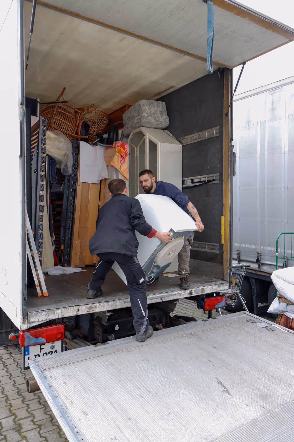 Lastwagen wird von zwei GRAVITAS Mitarbeitern gefüllt nach einem Seniorenumzug, Haushaltsauflösung oder Entrümpelung.