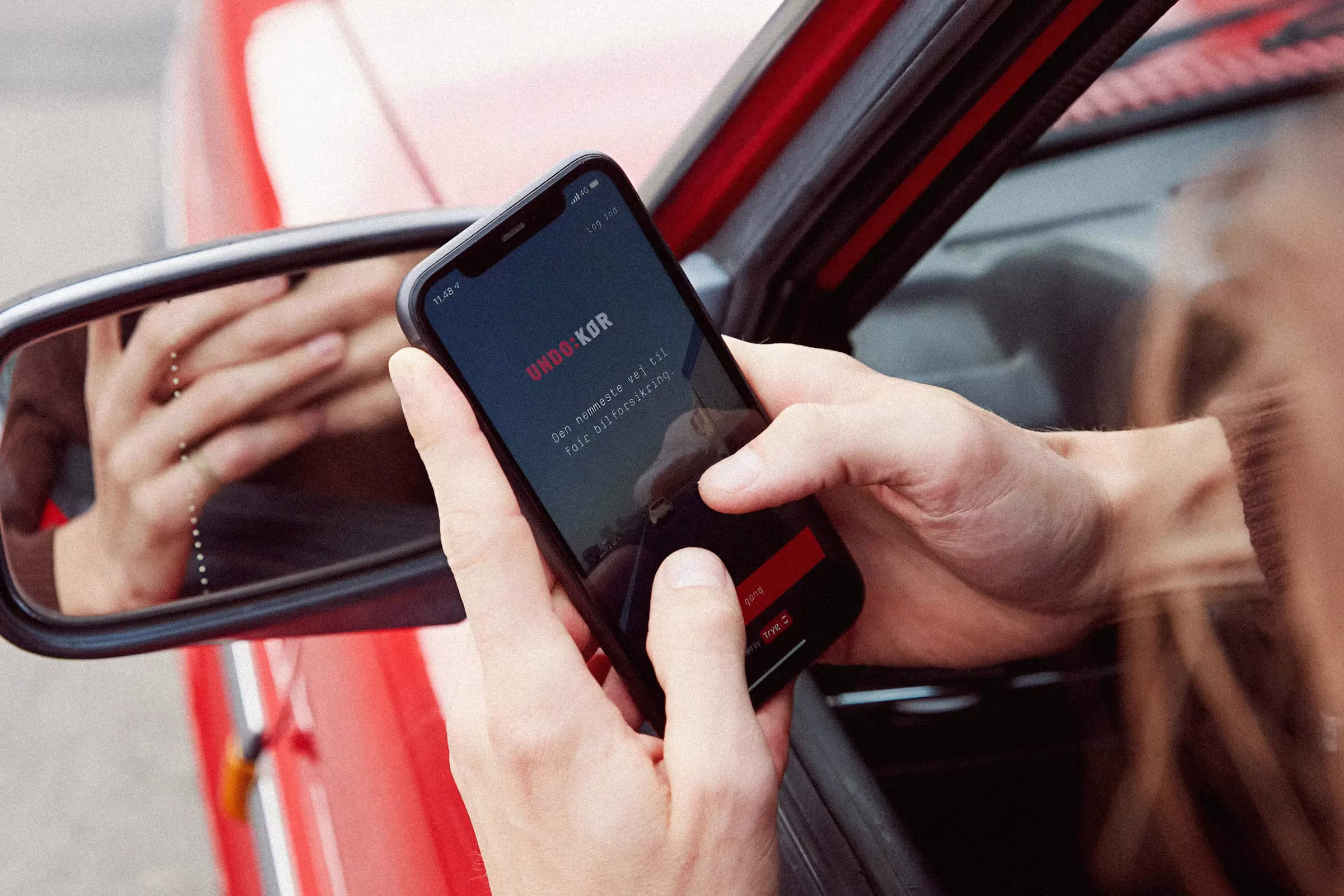 Person holding phone from a car window