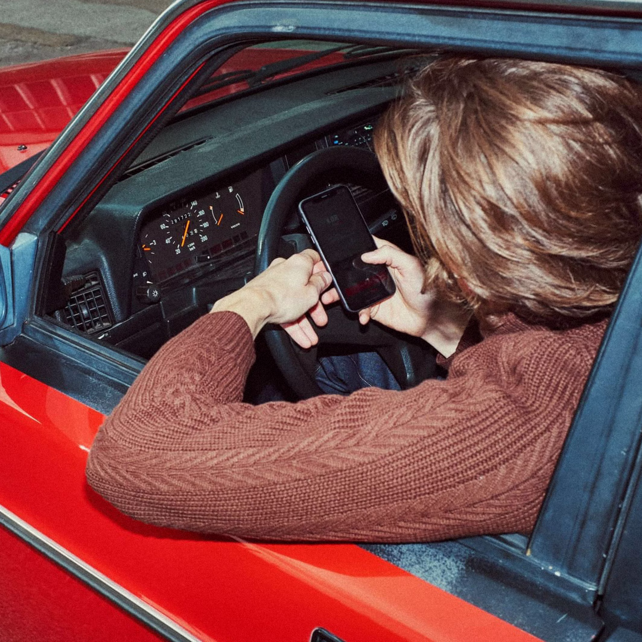 Person holding phone in a car