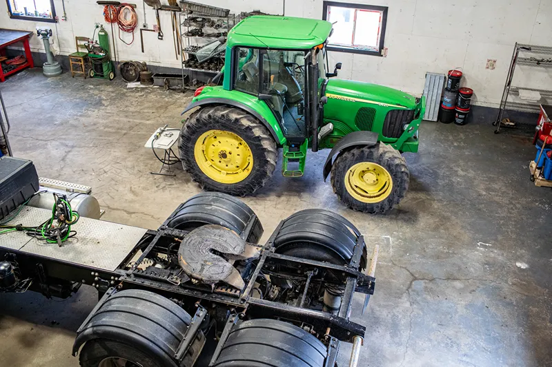 Central Alberta heavy-duty repair shop with a tractor beside a semi truck chassis in a clean service bay.