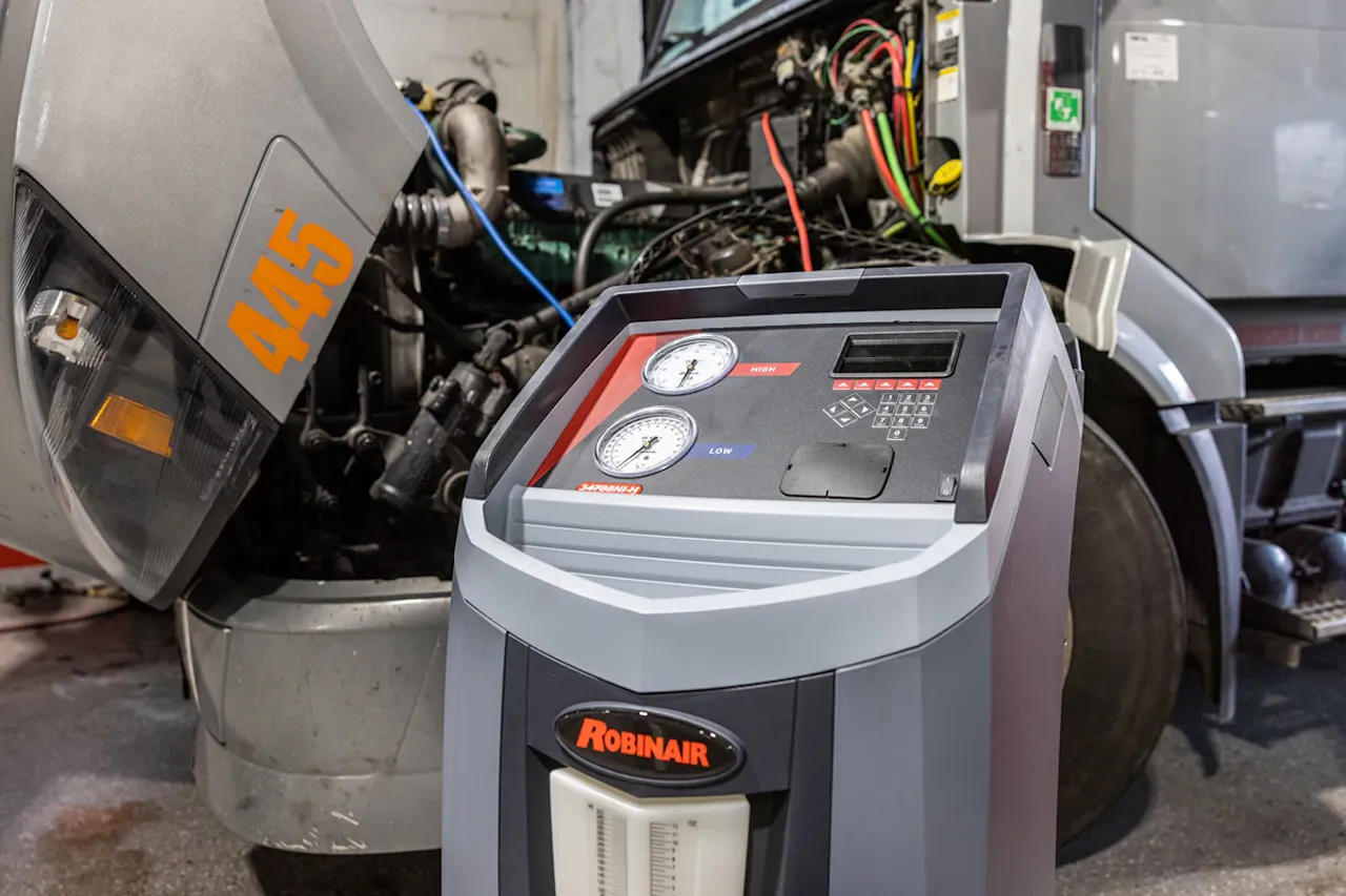 Heavy equipment HVAC service in Alberta uses a Robinair unit on a truck marked 445 to diagnose and recharge its A/C.