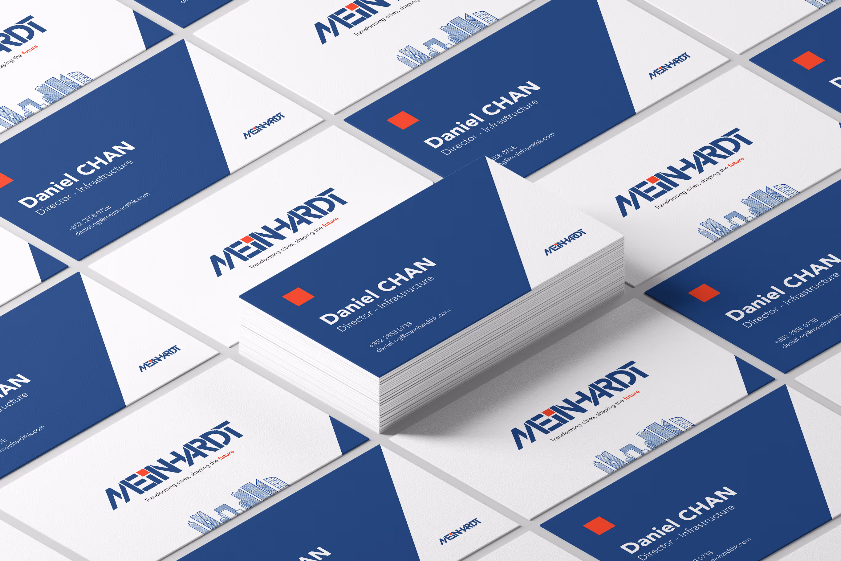Stack and layout of business cards for Daniel Chan, Director Infrastructure at Meinhardt with blue and white design and city skyline illustration.