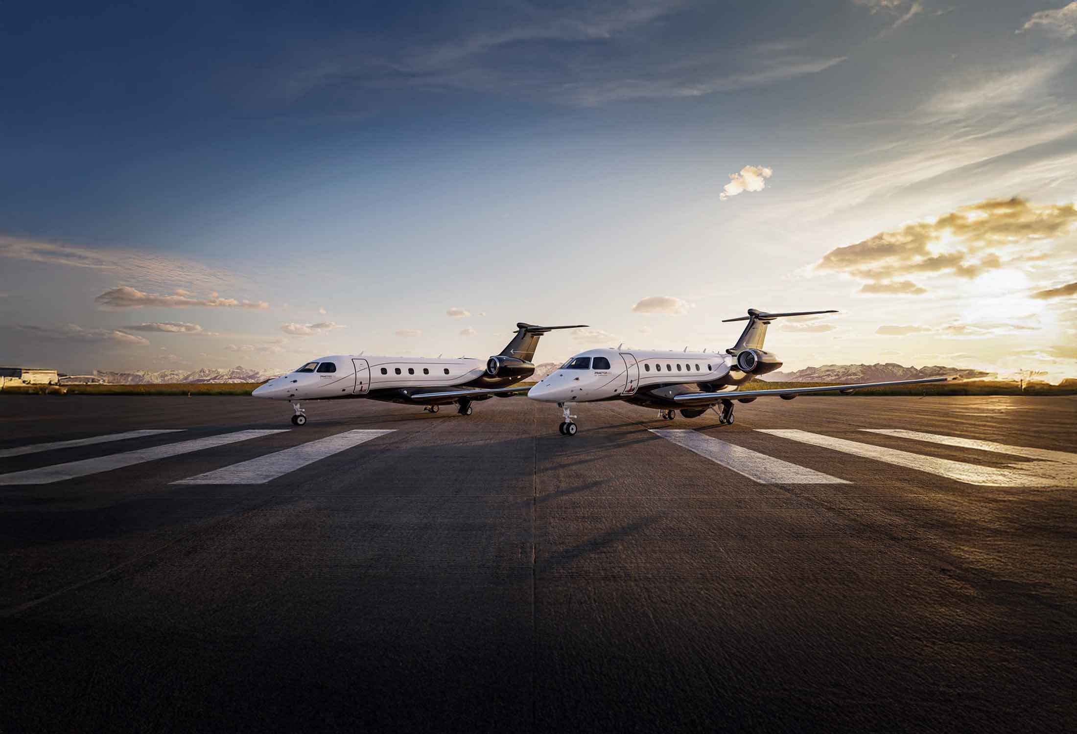 A pair of Embraer Praetor jets sit on the tarmac awaiting takeoff