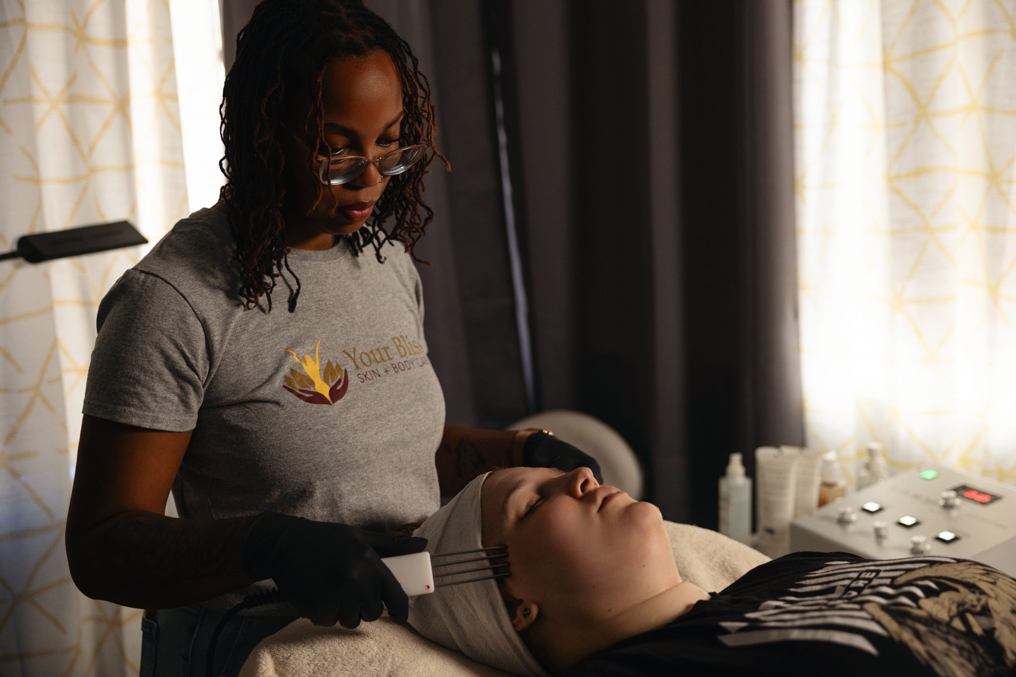 Giseleine using a facial device in the treatment room