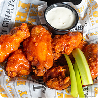 Close-up shot of wings and sauce with celery sticks.