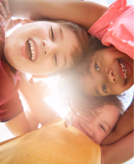 Three friends smiling looking downward.