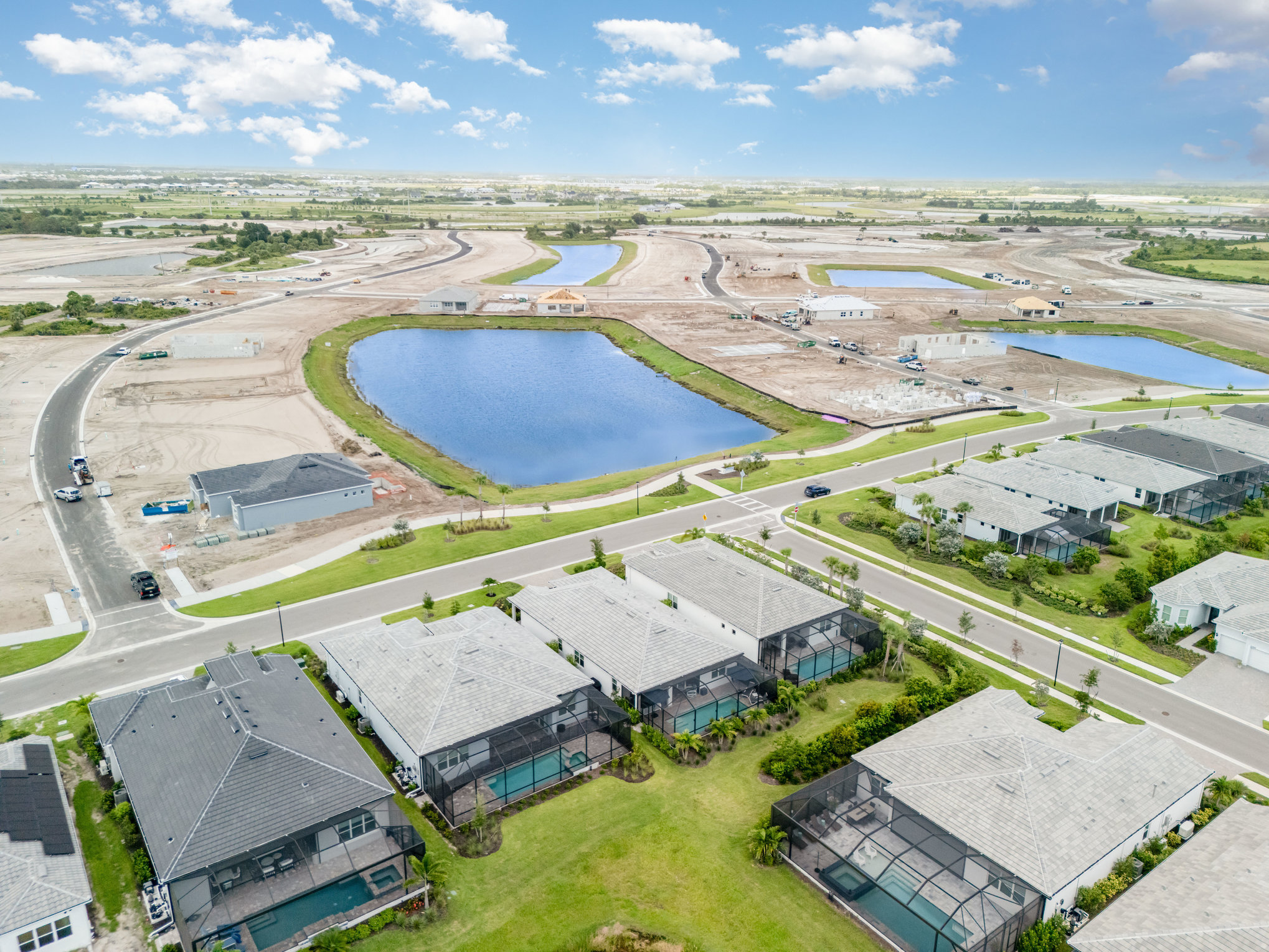 Aerial view of Englewood suburban development with houses, roads, construction sites, and ponds highlighting real estate g...