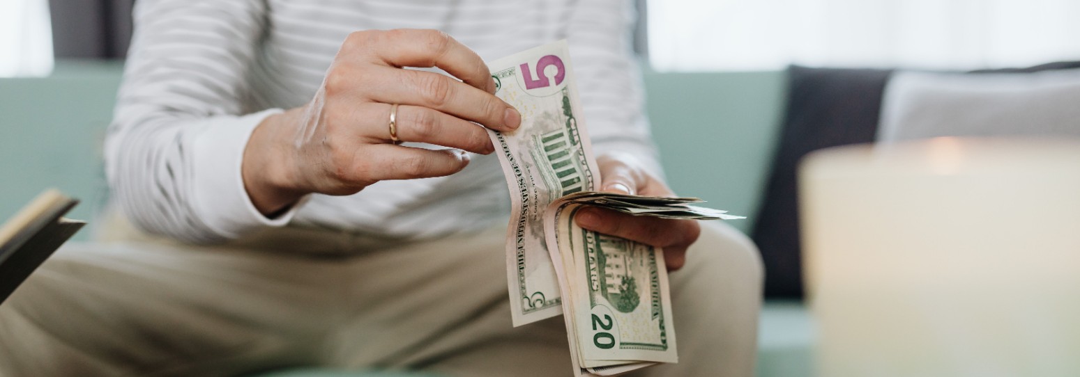 A person counting money sitting down