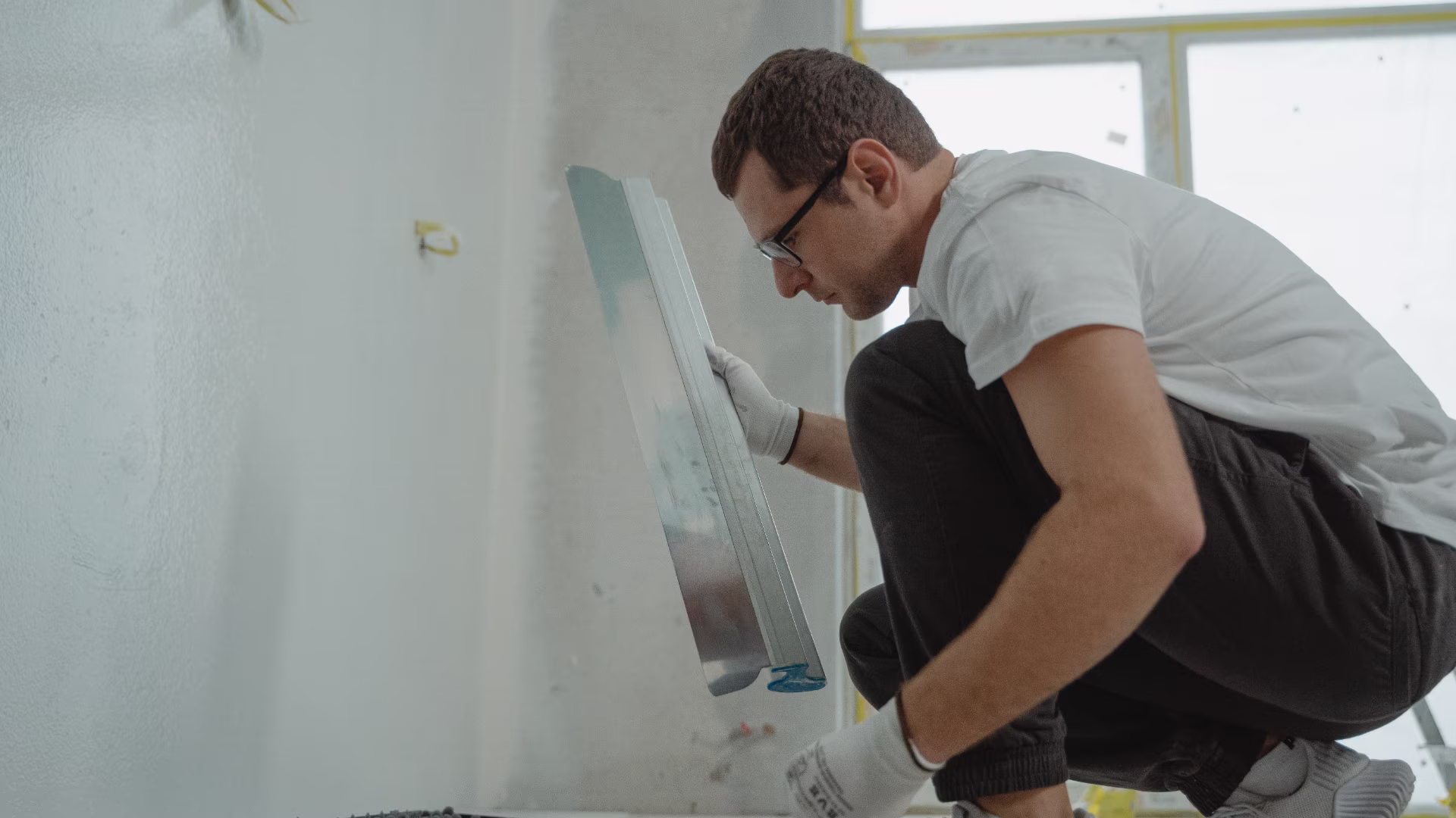 A person conducting renovations in an empty unfinished room