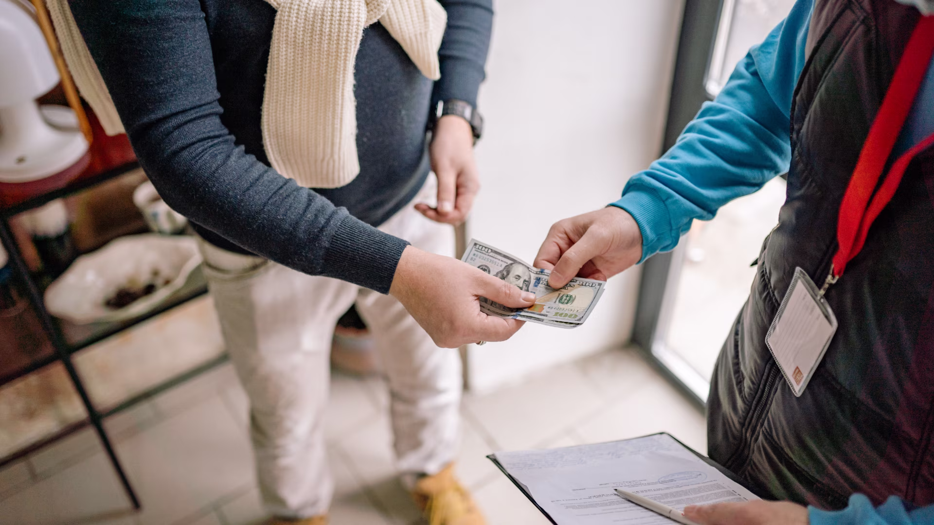 two people standing up exchanging cash with each other