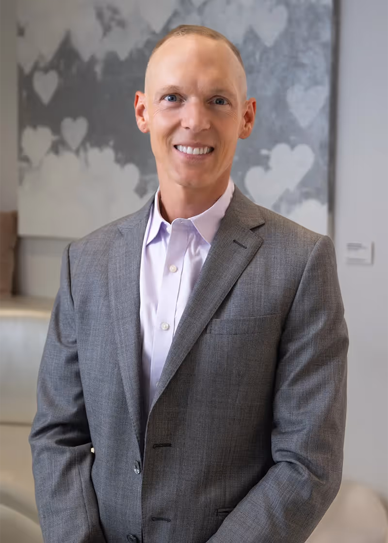 Dr. Siedhoff standing in the reception area of practice in grey suit.