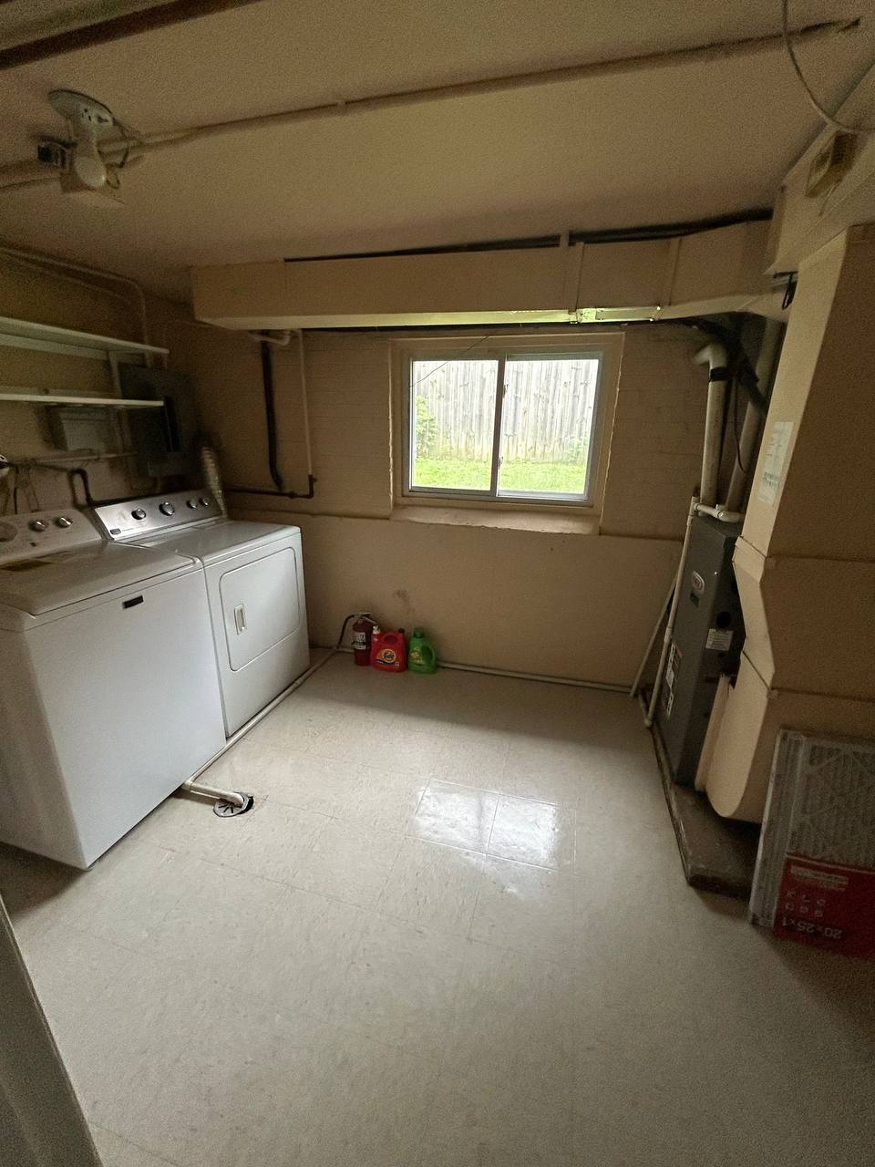 Basement laundry room with washer, dryer, furnace and tile floor