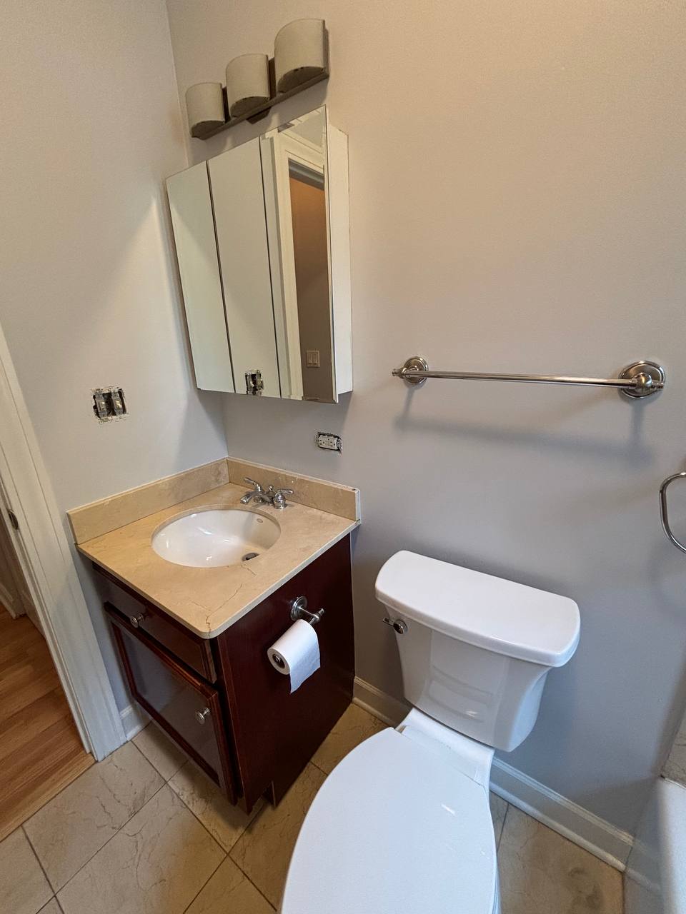 Small bathroom with dark vanity, mirrored cabinet and toilet