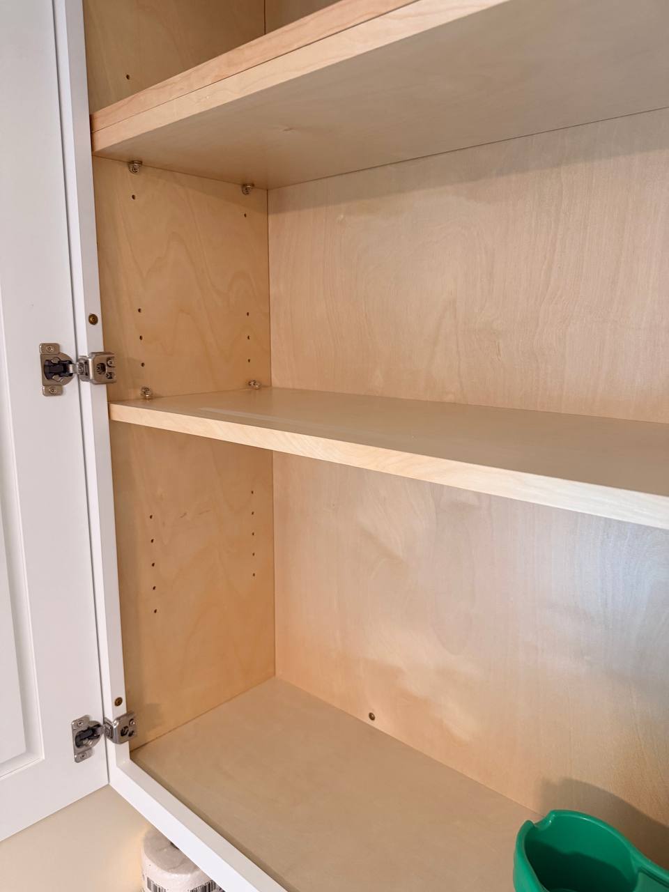 Empty light wood cabinet shelves with the door open