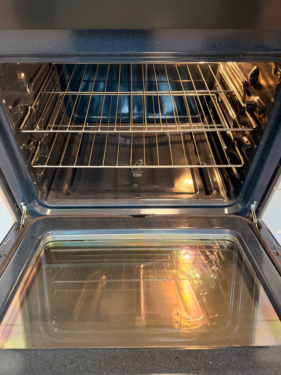 Open oven with clean racks and glass door