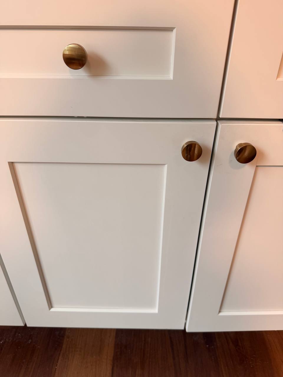 White shaker cabinet doors with round brass knobs