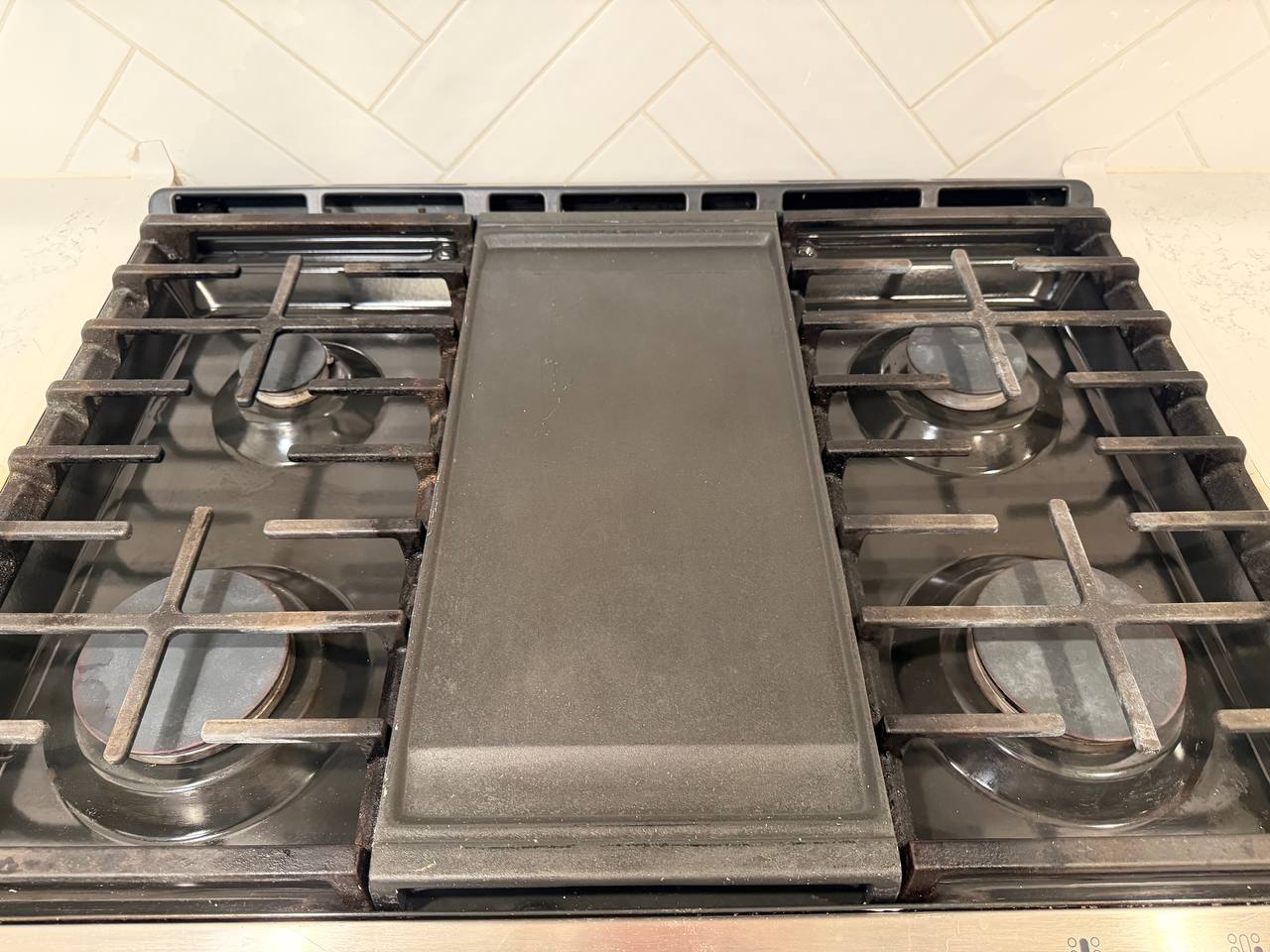 Gas stove top with cast iron grates and center griddle