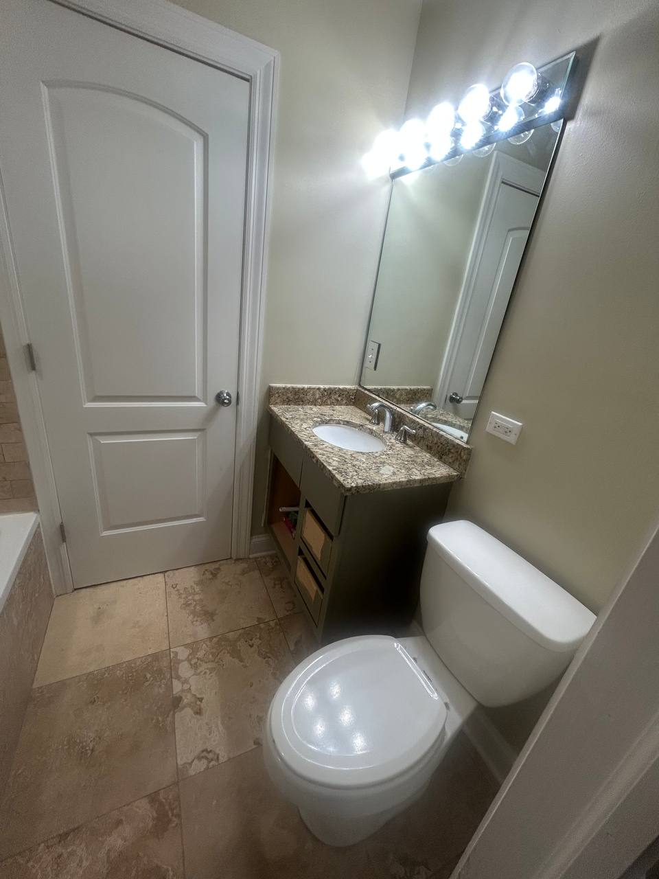 Small bathroom with granite vanity, toilet, tub and tile floor