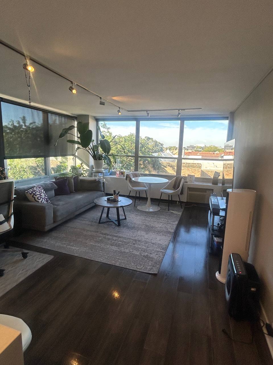 Living room with gray sofa, round white table and large windows