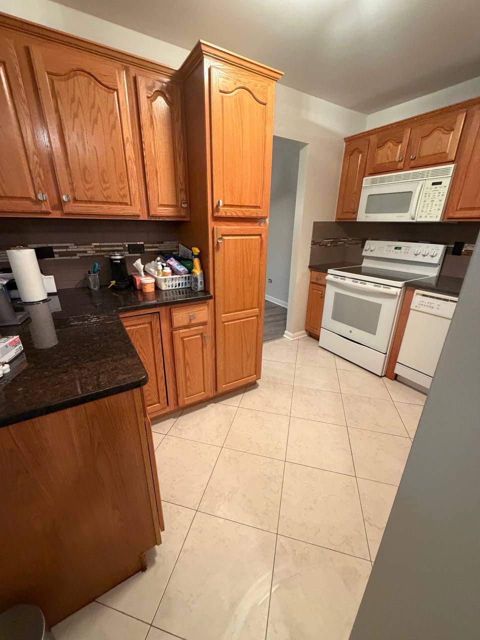 Kitchen with oak cabinets, dark granite counters and white stove
