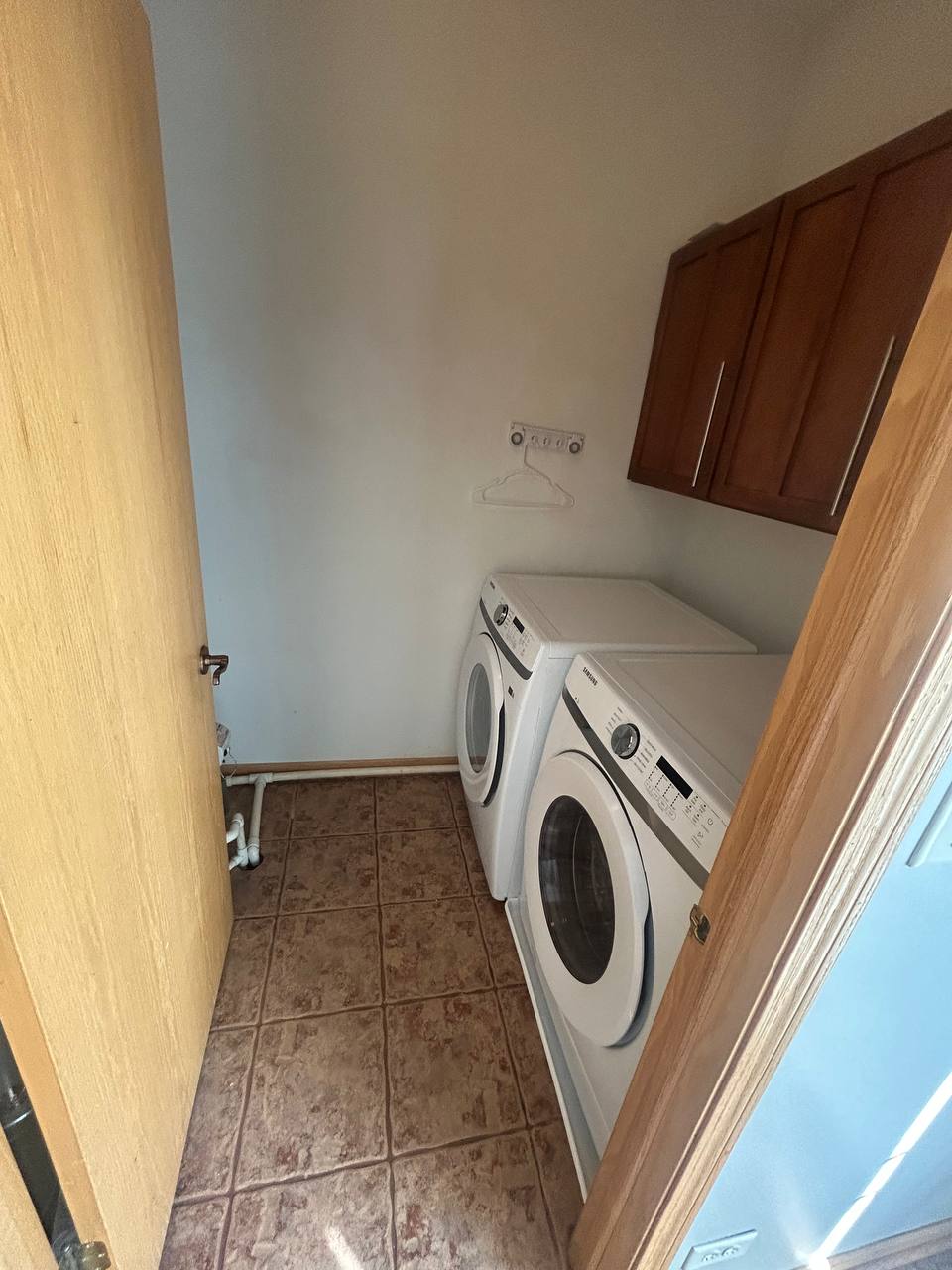 Laundry closet with white front load washer and dryer