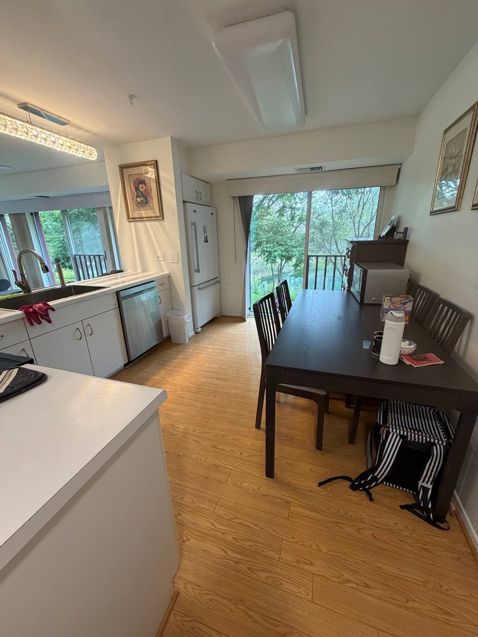Kitchen and dining area with dark table, white cabinets and patio door