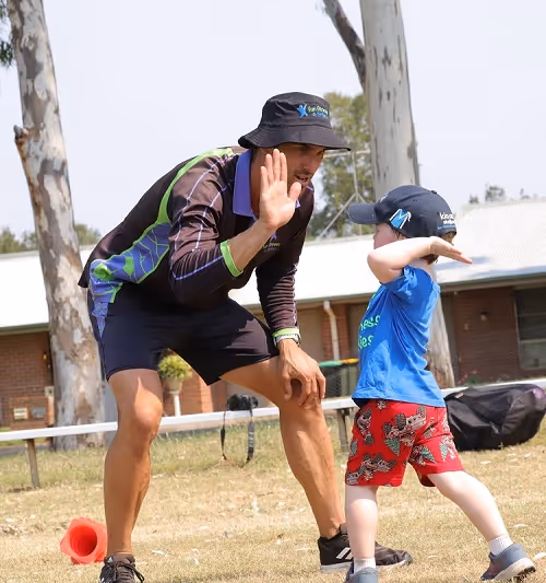A young boy high fiving a male school teacher